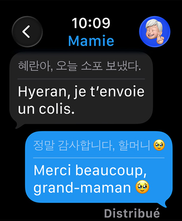Traduction en direct dans Messages, où un texto de remerciement d’une utilisatrice à sa grand-mère est automatiquement traduit en coréen, avec un émoji de clin d’?il sous la bulle de texte