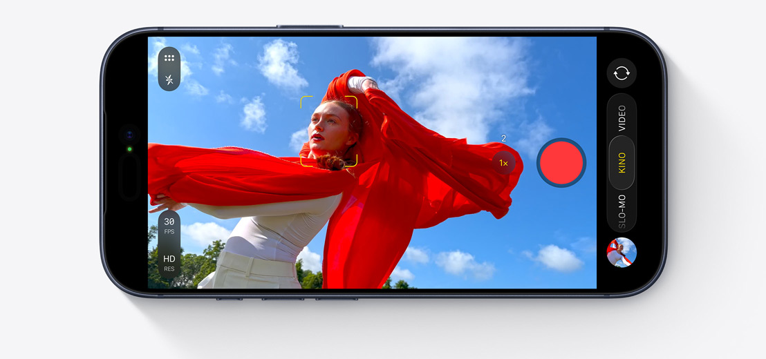 Ein iPhone Display zeigt den Kinomodus, der eine tanzende Person mit einem flie?enden roten Schal im Freien aufnimmt