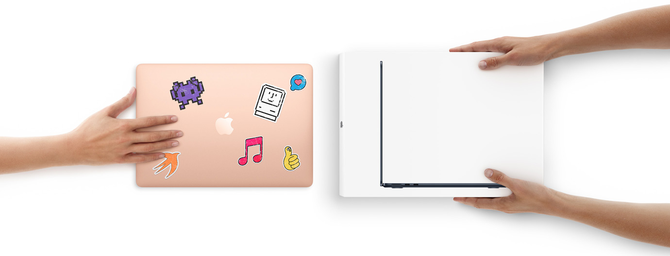 En h?nd f?rer en MacBook med klisterm?rker p? ydersiden hen mod to h?nder, der holder en spritny MacBook