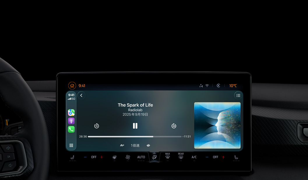 車の內(nèi)部、センターコンソールのディスプレイにCarPlay経由でApple Podcastの再生が表示されている。Radiolabの「The Spark of Life」のポッドキャストが現(xiàn)在再生されており、再生コントロールには早戻し、一時(shí)停止、スキップがある