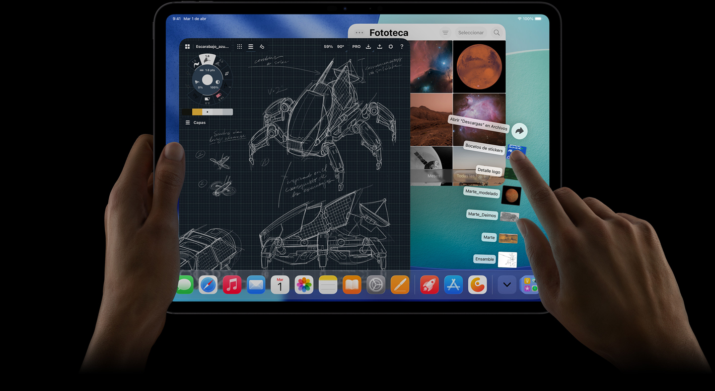 iPad Pro, parte frontal, posición horizontal, una mano derecha hace un gesto sobre archivos de la carpeta de descargas ubicados en forma de abanico, la pantalla muestra la interfaz de iPadOS 26 con varias apps abiertas incluida una app de edición de fotos que muestra los planos detallados de un robot y anotaciones escritas a mano, varias etapas del dise?o y la fototeca