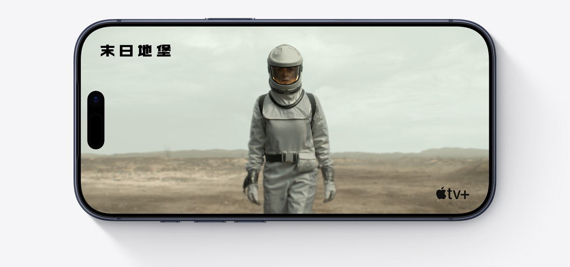 橫放的 iPhone 機(jī)身正面，展示 Apple TV+ 影集《末日地堡》的剪輯片段，畫(huà)面中的人身穿太空服