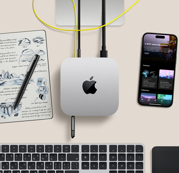 擺放在桌面的銀色 Mac mini 俯視圖，展示數(shù)條連接線和隨身碟插入連接埠，旁邊放著無線鍵盤、觸控式軌跡板、iPhone 和筆記本