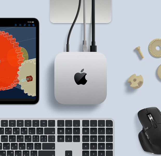 擺放在桌面的銀色 Mac mini 俯視圖，旁邊放著黑色配銀色的無線鍵盤、黑色無線滑鼠和一部 iPad